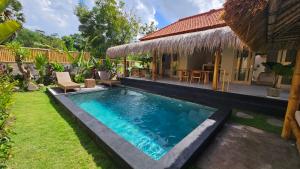 a swimming pool in a yard next to a house at Amed Saïta Villas in Amed