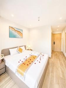 a bedroom with a large white bed with roses on it at LALU Hotel in Phú Quốc