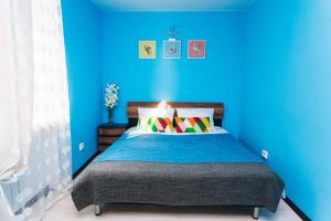 - une chambre bleue dotée d'un lit avec un mur bleu dans l'établissement Apartment on Popova 15, à Iekaterinbourg