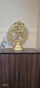 a gold clock sitting on top of a wooden cabinet at Jonaki Aalay-Cozy and Budget Stay-Ulubari in Guwahati +3 photos