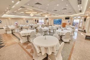 a banquet hall with white tables and white chairs at Teba Hotel Ras Elbar in Ras El Bar