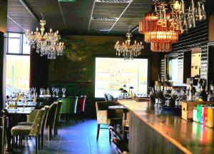 ein Restaurant mit einer Bar mit Kronleuchtern in der Unterkunft Centralhotellet Söderhamn in Söderhamn