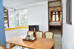 a dining room with a table and chairs and a bedroom at La Maison Mira in Pondicherry