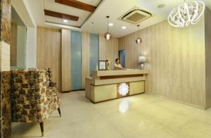 a woman standing at a counter in a hotel lobby at Rahitya Premier in New Delhi