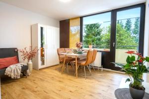 a living room with a table and chairs and a window at RELAX - ORANGE mit Pool und Sauna in Sonthofen