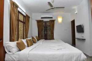 a large white bed in a room with a window at La Maison Mira in Pondicherry