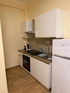 a kitchen with white cabinets and a sink and a refrigerator at Piccola Isola in Parma