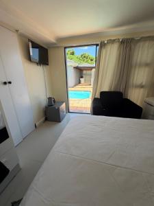 a bedroom with a bed and a view of a pool at Joys House in Cape Town