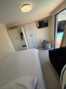 a bedroom with a white bed and a view of a pool at Joys House in Cape Town