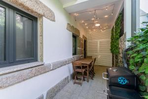 a patio with a table and chairs and a grill at Casa do Recanto - Loriga - Serra da Estrela in Loriga