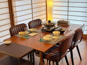 a wooden table with chairs around it with a bowl and dishes at 風まち in Yawatano