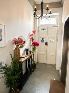a hallway with a door with flowers and a mirror at Iris -Paola Modern Townhouse in Paola