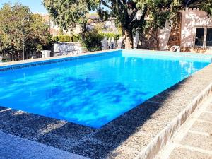 a large swimming pool with blue water at Casa Rural con piscina privada y jardines - LA CASILLA in Cájar +50 photos