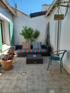 a patio with a couch and a table at Le Lohan in Port-Saint-Louis-du-Rhône