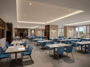 a dining room with tables and blue chairs at Wyndham Goseong Gangwon Hotel in Goseong