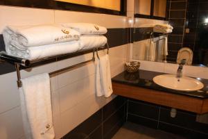 a bathroom with a sink and a pile of towels at Clarion Hotel Nairobi in Nairobi +56 photos