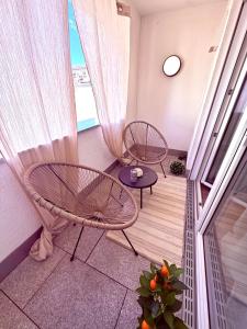 a balcony with two chairs and a table and a window at Stilvolles Apartment mit Balkon - zentrumsnah, self checkin in Augsburg