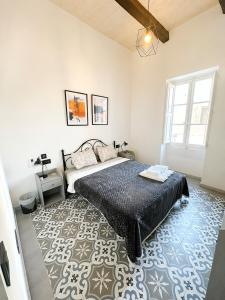 a bedroom with a bed and a rug at Iris -Paola Modern Townhouse in Paola +7 photos