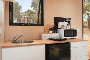 a kitchen with a sink and a microwave at Kiara By Tiny Away in Stawell