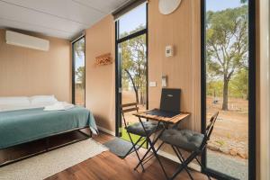 a bedroom with a bed and a desk with a laptop at Kiara By Tiny Away in Stawell
