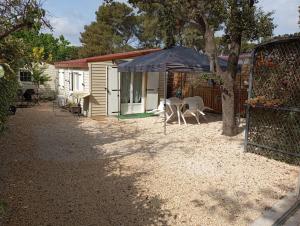 a house with a table and chairs in a yard at Mobil-home LOFT tout équipé Le Castellet les pins doux in Le Castellet