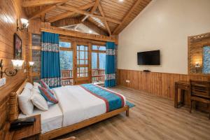 a bedroom with a bed and a desk and a television at 8fold by Larisa, Jibhi in Jibhi