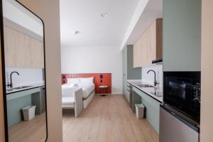 a room with a bed and a kitchen with a sink at Flipco Retiro in Madrid