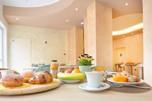 a table topped with plates of food and fruit at Hotel Corallo New in Muravera