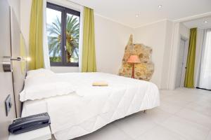 a bedroom with a large white bed and a window at Hotel Corallo New in Muravera