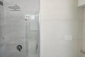 a shower with a glass door in a bathroom at Hotel Corallo New in Muravera +59 photos