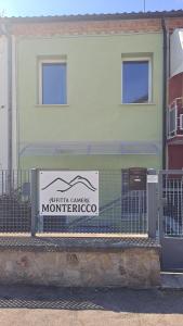 a sign on a fence in front of a building at Monte Ricco Appartamenti in Monselice