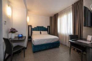a hotel room with a bed and a desk at Hotiday Napoli Porto in Naples