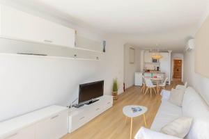 a living room with a white couch and a tv at Apartment Vida Sana by Sealand Villas in Alcudia