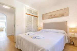a white bedroom with two towels on a bed at Apartment Vida Sana by Sealand Villas in Alcudia