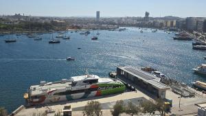 a boat docked at a dock in a harbor at Unique Seafront Triplex Penthouse with Panoramic Bedroom & Rooftop Jacuzzi overlooking Valletta in Sliema +151 photos