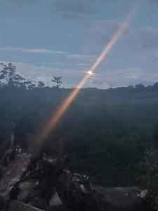 a beam of light in the sky over a forest at Orchard House North in Pergola