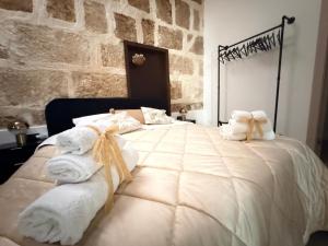 a bedroom with a large bed with towels on it at Kymata Home in Avola