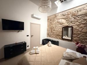 a bedroom with a bed and a television on the wall at Kymata Home in Avola