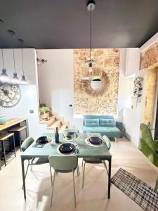 a living room with a table and green chairs at Kymata Home in Avola