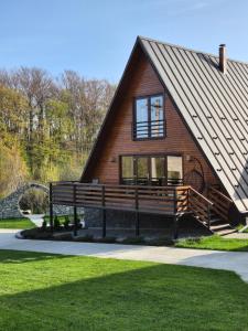 a house with a large bench in front of it at Twin Cabins / Cabanele Gemene in Suceava