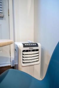 a white heater in a room with a blue chair at Near the Ferry - Studio de charme in Lévis