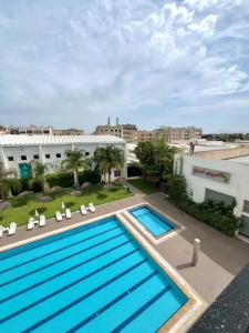 eine Draufsicht auf ein Schwimmbad auf einem Gebäude in der Unterkunft Eventi Club by cité des sports adarissa in Fès
