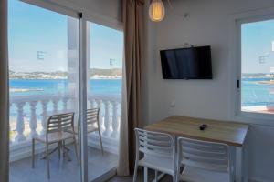 a dining room with a table and chairs and a large window at ENDLSS BEACH & DISCO HOTEL IBIZA Adults Only in San Antonio Bay