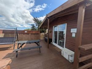 a wooden deck with a bench on the side of a building at The Viewpoint in Deal