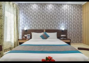 a bedroom with a large bed with two night stands at Royal Residence Golf Course Road in Gurgaon