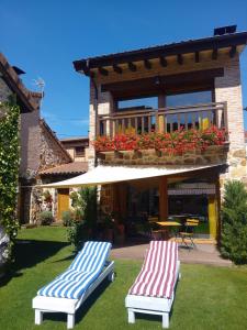 two blue and white chairs sitting on the grass in front of a house at La Galiana loft nature in Casarejos