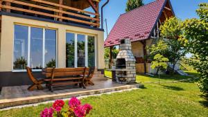 a wooden bench sitting on a deck next to a house at Danube Escape with Jacuzzi, Pool & Spacious Yard by Destination GREEN Croatia in Bogaljevci