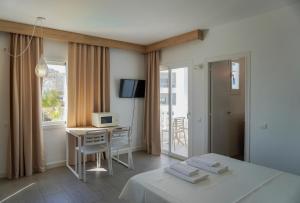a bedroom with a bed and a desk and a television at ENDLSS BEACH & DISCO HOTEL IBIZA Adults Only in San Antonio Bay