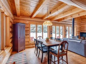 a dining room and living room with a table and chairs at Spa & River - Hidden chalet - Chalet cache in Saint-Alexis-des-Monts