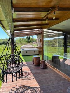 a porch with a swinging bench and a grill at O REFUXIO DOS CEBREIROS in Mazaricos